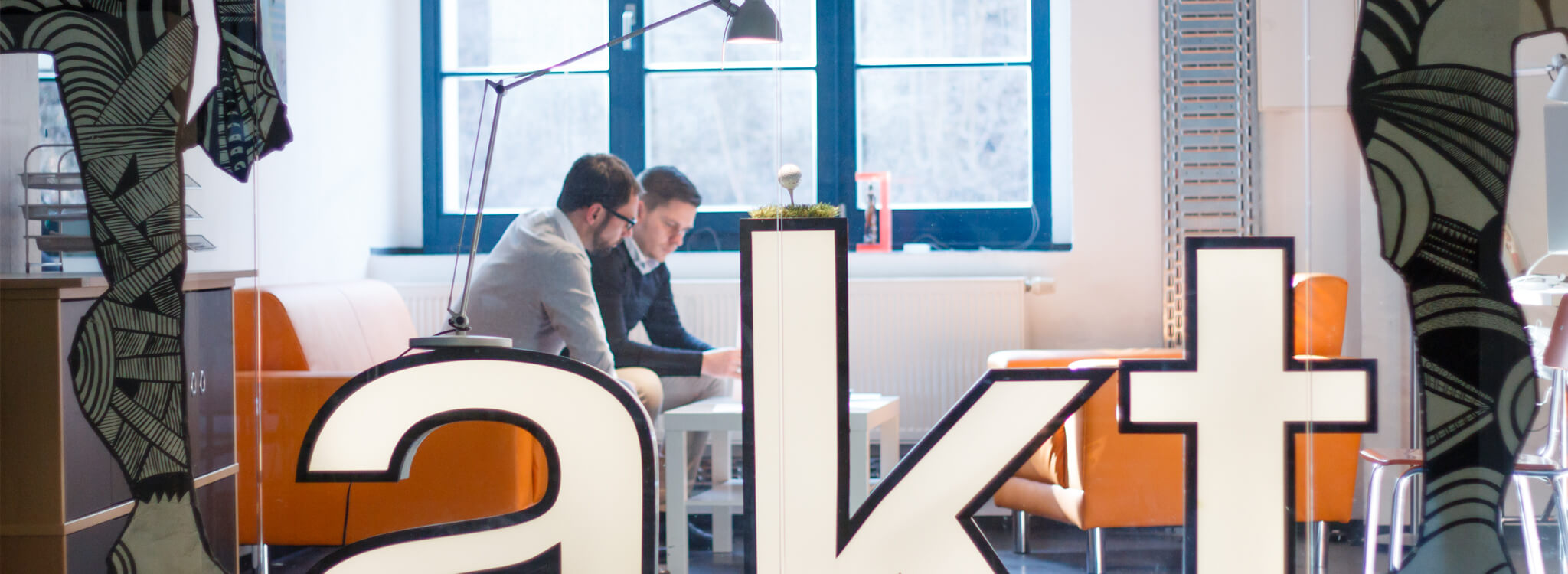 Zwei Mitarbeiter unterhalten sich in einem Büro